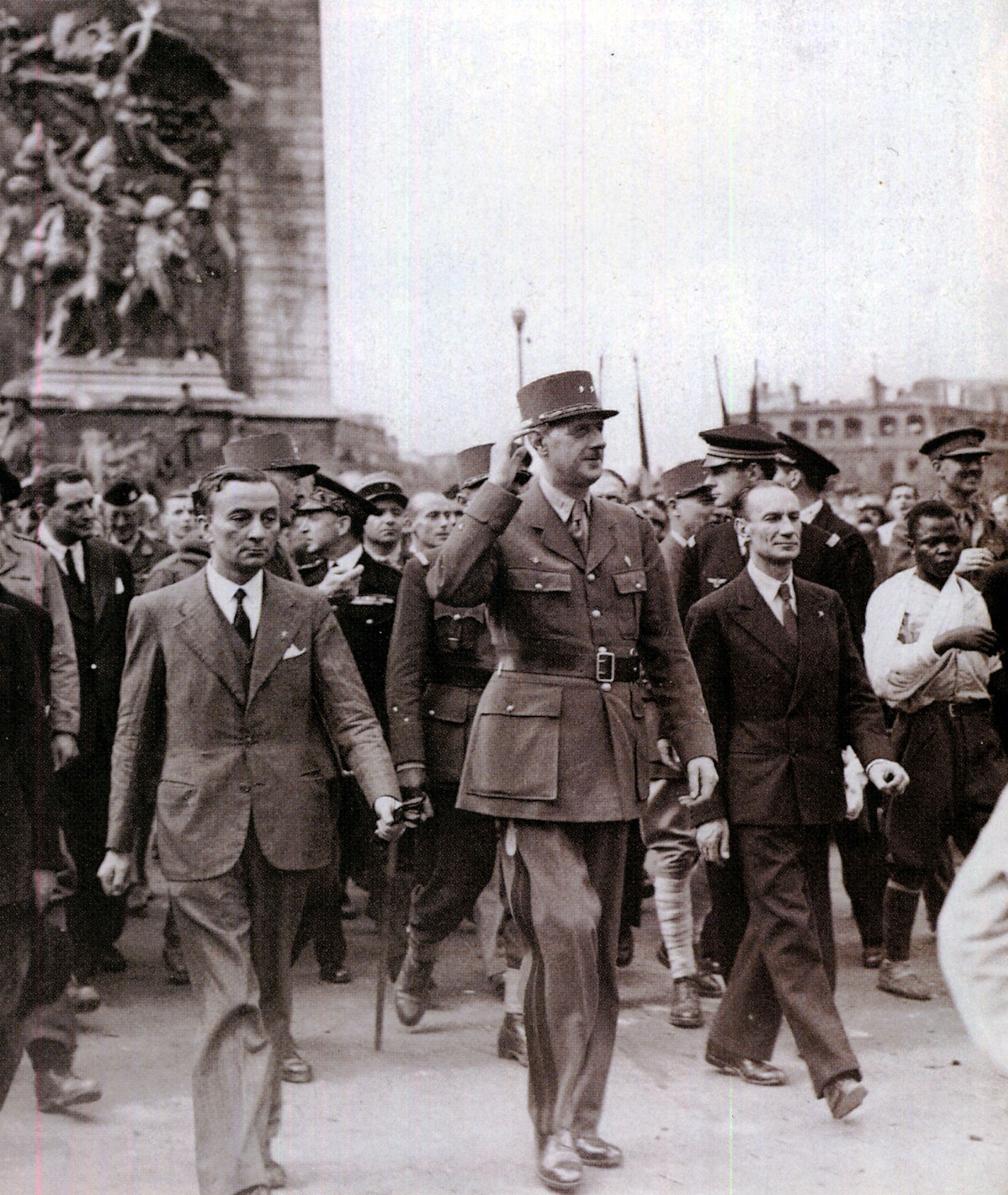 Le général de Gaulle accompagné de Georges Bidault (à gauche) et Alexandre Parodi (à droite) descend les Champs-Elysées. A droite on aperçoit Georges Dukson. Le général de Gaulle accompagné de Georges Bidault (à gauche) et Alexandre Parodi (à droite) descend les Champs-Elysées. A droite on aperçoit Georges Dukson.