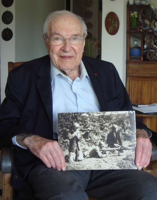 Portrait d'Hubert Cloix pris en 2017. Il tient  entre ses mains une photographie du groupe PIAT. 
Photo Frantz Malassis